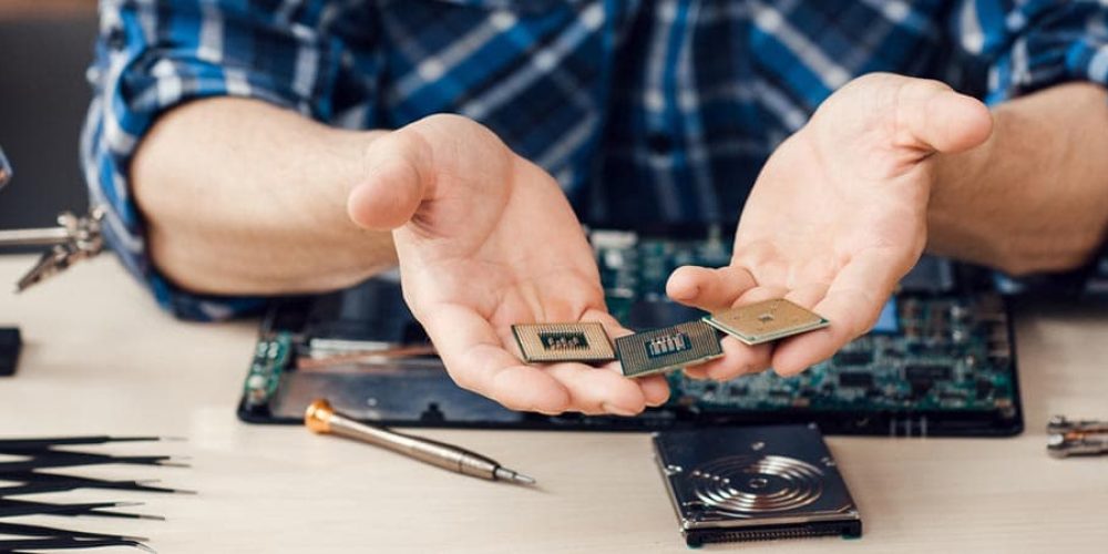 Computer microchips in male hands, close-up. Computer repair shop, electronic engineer workplace with necessary tools.